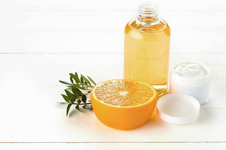 Bottle of cleansing oil with a pump dispenser next to a cotton pad, used for removing makeup and impurities