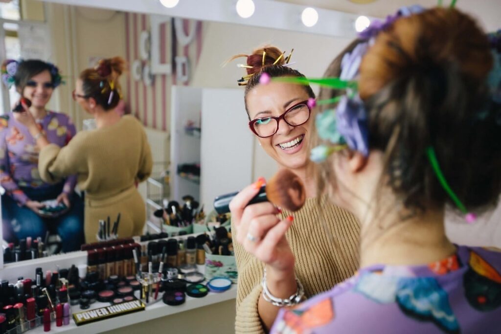 Close-up of a variety of makeup products, including lipstick, eyeshadow, and foundation, arranged neatly on a vanity